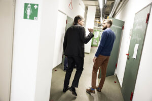 FAU President Hornegger and Prof. Dr. Fuhrmann are talking in a hallway.