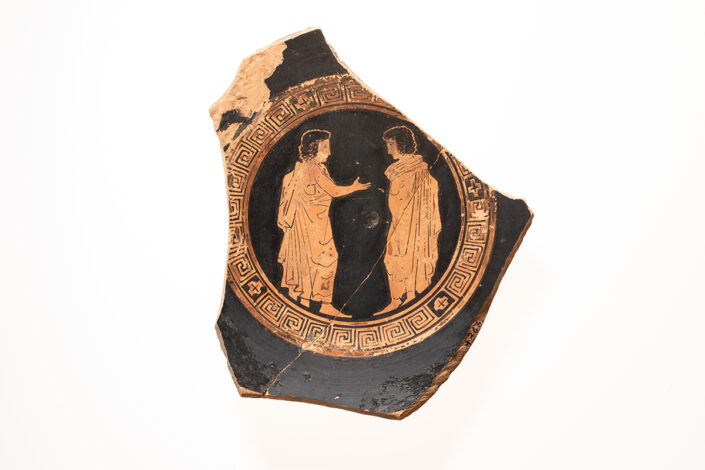 Red-figure shard with two young citizens greeting each other.